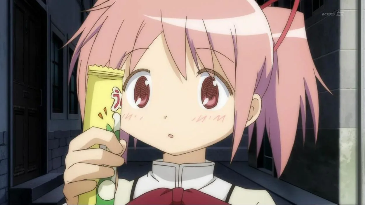 Madoka Kaname with a candy in her hand looks stunned.